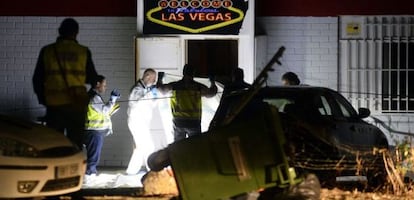 Miembros de la policía científica buscan restos en el bar.