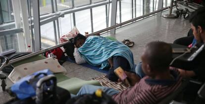 Un pasajero descansa en el suelo, en la terminal 5 del aeropuerto de Heathrow (Londres), el lunes.