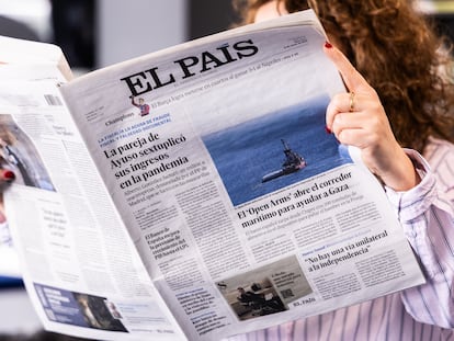 Una mujer lee EL PAÍS en su edición impresa.