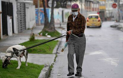 Um homem usa uma máscara facial como medida preventiva contra a propagação do novo coronavírus, enquanto passeava com seu cachorro em Bogotá, em 16 de março de 2020.