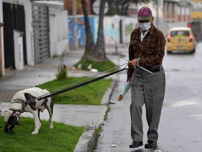 Um homem usa uma máscara facial como medida preventiva contra a propagação do novo coronavírus, enquanto passeava com seu cachorro em Bogotá, em 16 de março de 2020.