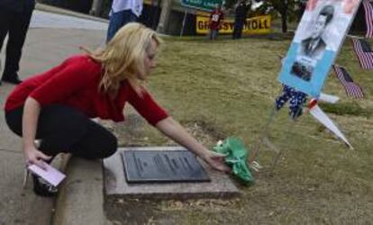 Una mujer deposita un ramo de flores en el lugar donde fue asesinado John F. Kennedy el 22 de noviembre de 1963. EFE/Archivo