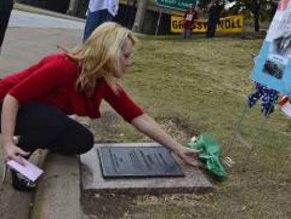 Una mujer deposita un ramo de flores en el lugar donde fue asesinado John F. Kennedy el 22 de noviembre de 1963. EFE/Archivo