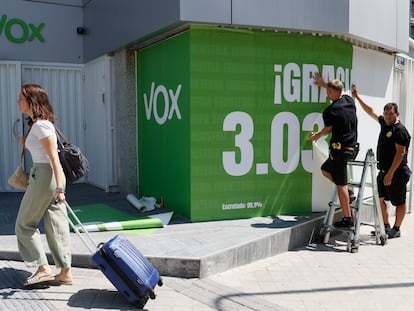 Dos operarios con la pancarta con los datos obtenidos por Vox en las elecciones del 23-J en la fachada de la sede del partido, el lunes en Madrid.