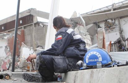 Una joven de los cuerpos de rescate se toma un respiro de las labores de búsqueda de supervivientes en el edificio que se desplomó en Concepción