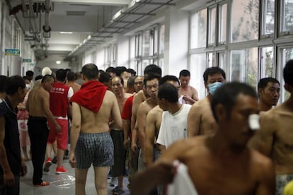 Algunos de los ciudadanos evacuados hacen cola para recibir ropa donada en el refugio temporal abierto en una escuela en Tianjin.