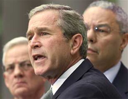 George Bush habla a la prensa acompañado de Colin Powell y del secretario del Tesoro, Paul O'Neill.