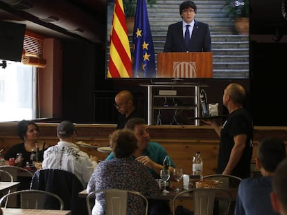 Gente en un bar mirando el discurso de Puigdemont.