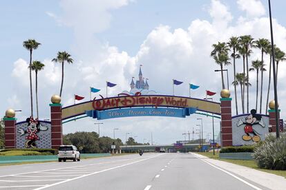 Cars drive under a sign greeting visitors near the entrance to Walt Disney World, July 2, 2020, in Lake Buena Vista, Fla.