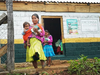 Dos mujeres salen de un tienda cargando productos de Segalmex.