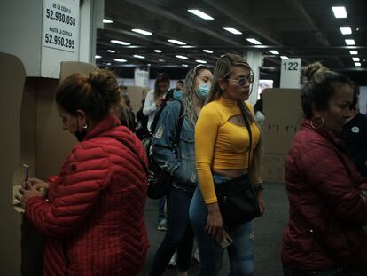 Mujeres hacen fila mientras otra vota el 19 de junio de 2022 en Bogotá.