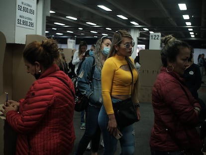 Mujeres hacen fila mientras otra vota el 19 de junio de 2022 en Bogotá.