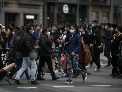 Decenas de personas cruzan el paso de peatones que comunica la plaza de Catalunya con la Rambla en Barcelona.