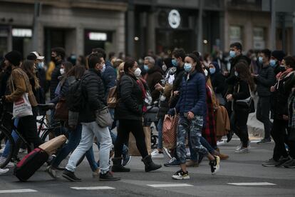Decenas de personas cruzan el paso de peatones que comunica la plaza de Catalunya con la Rambla en Barcelona.