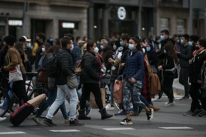 Decenas de personas cruzan el paso de peatones que comunica plaza Catalunya con la Rambla en Barcelona