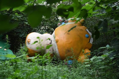 Yingying, una de las cinco mascotas de los Juegos Olímpicos de Beijing 2008, tumbada entre los árboles detrás de un centro comercial abandonado y nunca terminado en Beijing.