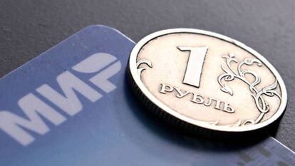 Montaje de una moneda de rublo y una tarjeta de crédito rusa.