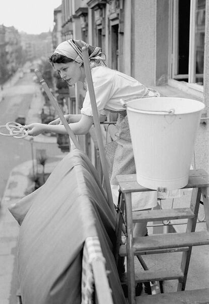 Woman with Cleaning Equipment on Balcony