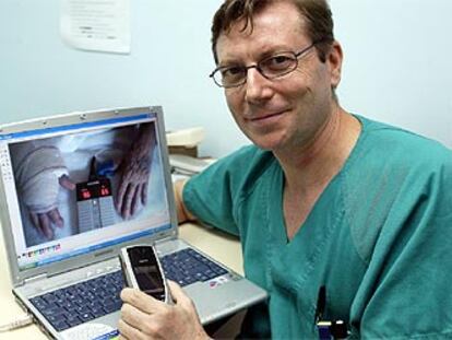 El doctor Juan Viñoles con la aplicación de telemedicina para seguimiento posoperatorio.