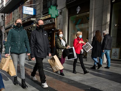 Varias personas con bolsas pasean en una calle comercial del centro de Madrid, el 2 de enero.