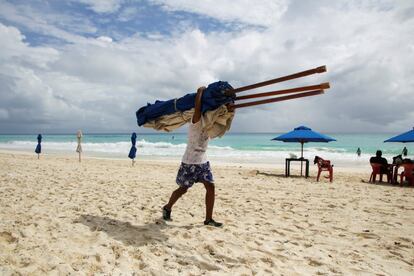 Un prestador de servicios turísticos recoge todo el mobiliario en las playas de Quintana Roo. 