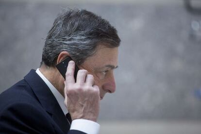 Mario Draghi, presidente del BCE, habla por teléfono en la sede del FMI en Washington.