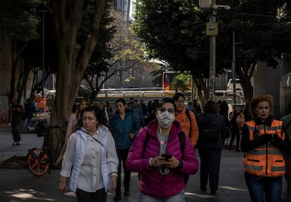 Una mujer camina con un cubre bocas en Ciudad de México este viernes.