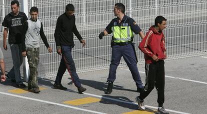 Un agente custodia a un grupo de inmigrantes en Algeciras.