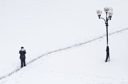 Un hombre toma una fotografía de la nieve con una tableta en un parque de Kiev.