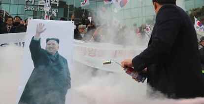 Manifestantes intentan quemar la imagen del lider norcoreano en Seúl.