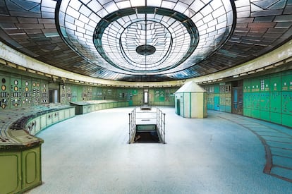 The Kelenföld power plant (Hungary). 'The Atlas of Abandoned Places' sets itself apart from other urban exploration compilations by clearly identifying many of the sites it explores, providing both name and location. However, this does not mean they are safe or easy to visit. Roman Robroek, the photographer of this image, was only permitted to document a small portion of the vast Kelenföld power plant, which is divided into an abandoned section and a portion still in use, managed by a private company.
More than a century old, the power plant was once the most modern in Europe and is considered a jewel of Hungarian industrial heritage. Its control room, decommissioned since 2005, is, by Robroek’s account, “the most beautiful my eyes have ever seen,” due to its impressive art deco glass ceiling. Designed in 1927 by architects Kálmán Reichl and Virgil Borbíró, the structure is legally protected, preventing its demolition but also discouraging renovation.