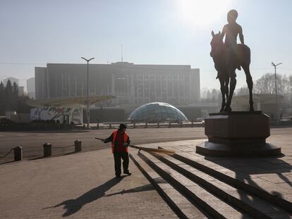 A worker sweeps a square near a fragment of Independence Monument and the city administration headquarters, which was set on fire during recent protests triggered by fuel price increase, in Almaty, Kazakhstan January 12, 2022. REUTERS/Pavel Mikheyev