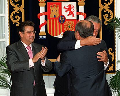 Javier Arenas abraza a José Torres Hurtado ante Juan Ignacio Zoido.