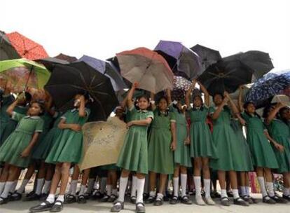Escolares indias abren sus paraguas para protegerse de la radiación ultravioleta, que aumenta por la reducción de la capa de ozono, en Hyderabad
