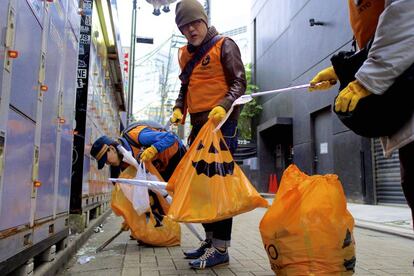 Voluntarios retiran la basura de Halloween en las calles de Tokio.