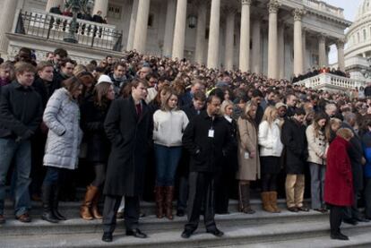 Personal y funcionarios del Congreso de EE UU guardan un minuto de silencio por las víctimas del atentado de Tucson ayer en las escaleras del Capitolio.