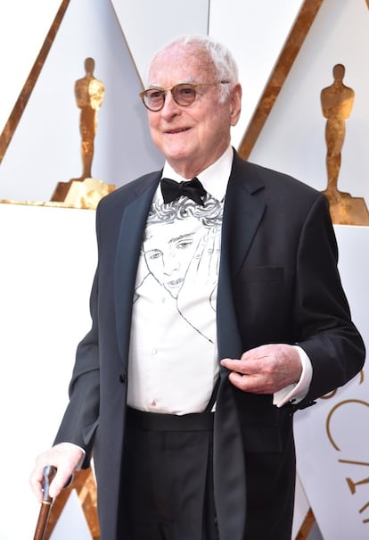 El guionista de 'Call me by your name', James Ivory, ha seguido la estrategia del director de 'Torrente' (Santiago Segura siempre viste camisetas con el nombre de sus películas cuando está de promoción) y se ha plantado en la alfombra roja con la cara del protagonista de la cinta –Timothée Chalamet– grabada en su camisa. Más estilosa que las camisetas de Segura es.