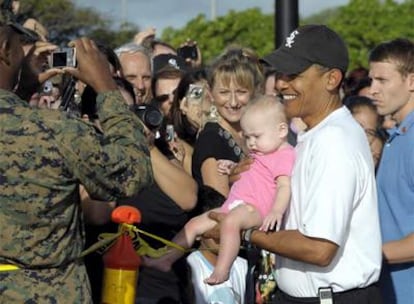 Obama posa con un bebé en Hawai, donde pasa sus vacaciones.