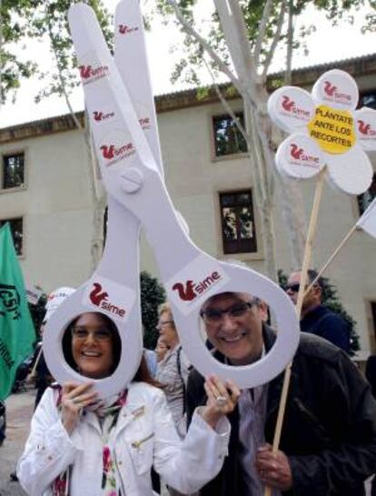 Dos personas sostienen unas tijeras de gran tama?o durante una concentracin, en la que han participado medio millar de sindicalistas de UGT, CCOO, INTERSINDICAL, CSIF, ANPE, SATSE, y SIME, hoy ante el Palacio de San Esteba de Murcia.