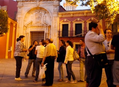 Un grupo de personas hoy frente a las puertas cerradas de la basílica de Jesús del Gran Poder.
