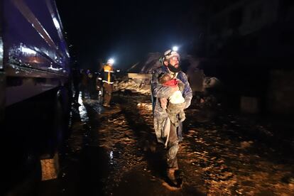 Un hombre, tras rescatar a un bebé en la ciudad siria de Zardana, la madrugada de este lunes.