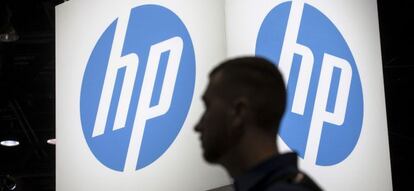 Una persona pasa por delante de un logo de HP.