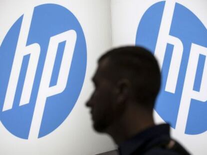 Una persona pasa por delante de un logo de HP.