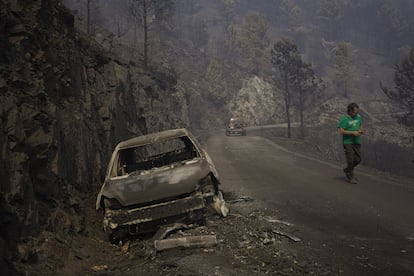 Rober, vecino de la aldea de Paradaseca observa el estado en el que quedó un vehículo calcinado por las llamas.