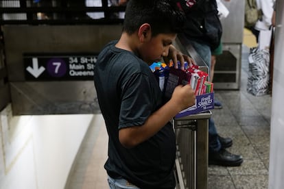 A child checks the merchandise he is selling inside a New York subway station. 