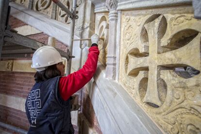 Una restauradora se emplea, pincel en mano, en un detalle a la entrada del recinto.