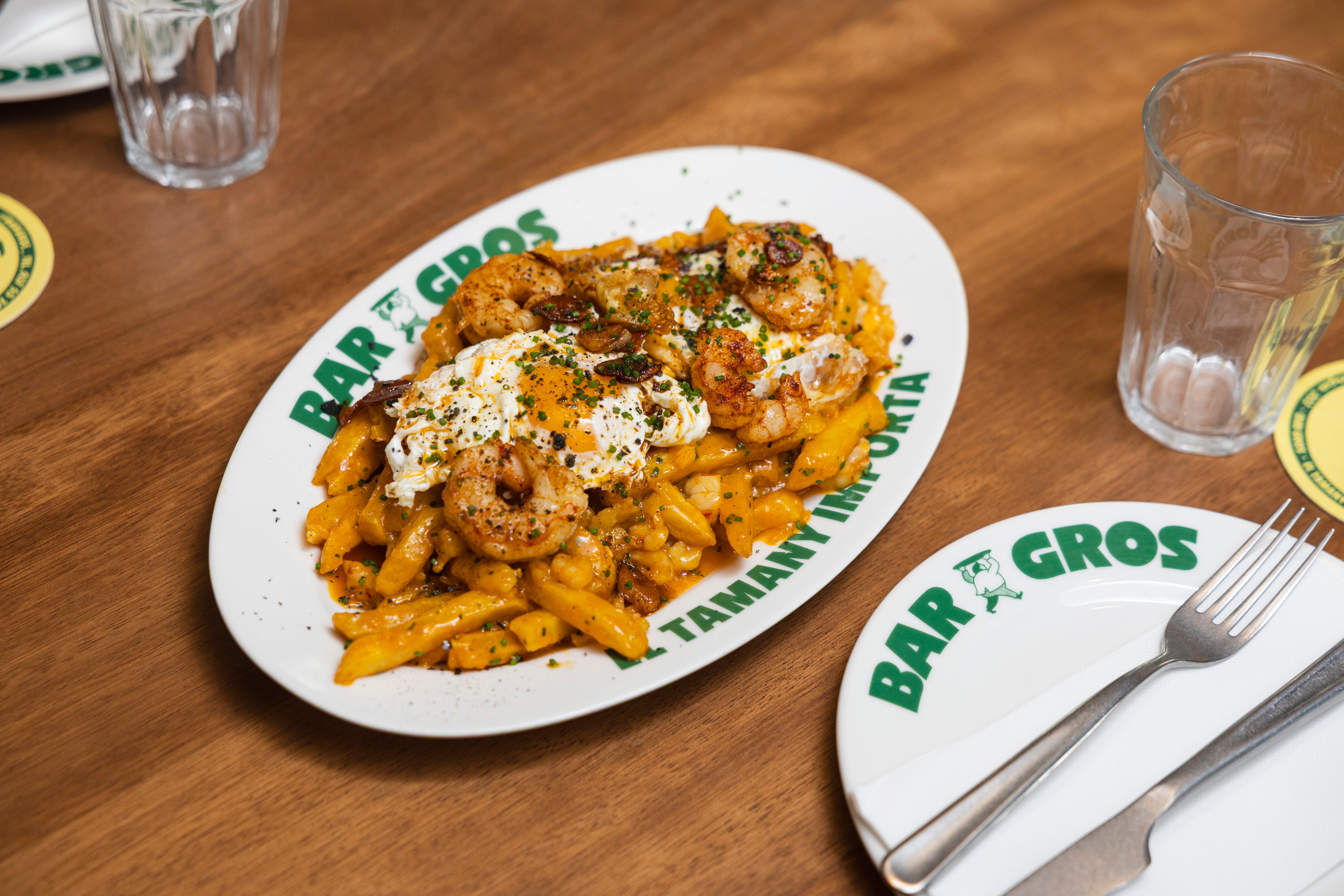 Huevos rotos con gambas al ajillo, de Bar Gros.