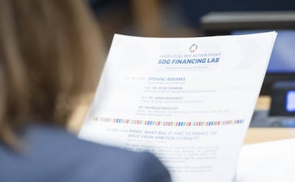 Una asistente lee el programa de un evento sobre financiación de los ODS.