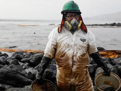 Un hombre trabaja en la limpieza de una playa peruana afectada por el vertido.
