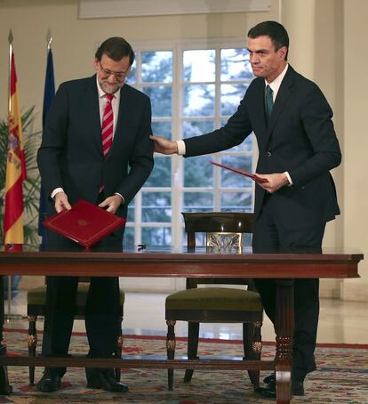 El presidente del Gobierno, Mariano Rajoy (i), y el secretario general del PSOE, Pedro Sánchez, durante la firma de su primer pacto de Estado, el 'Acuerdo para afianzar la unidad en defensa de las libertades y en la lucha contra el terrorismo', en el Palacio de la Moncloa.